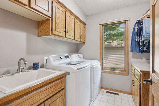21273 Floral Bay Dr N, Forest Lake, MN 55025 - washroom with washing machine and clothes dryer, cabinet space, and a textured ceiling
