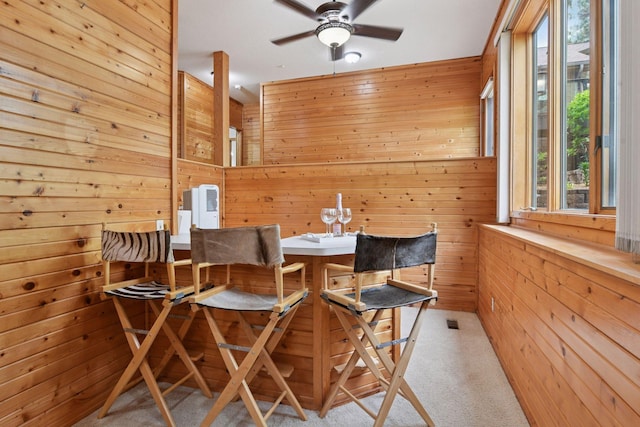 21273 Floral Bay Dr N, Forest Lake, MN 55025 - dining room featuring wood walls, ceiling fan, and carpet floors