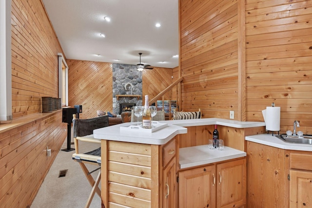 21273 Floral Bay Dr N, Forest Lake, MN 55025 - kitchen featuring wood walls, ceiling fan, carpet, a fireplace, and open floor plan