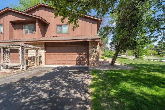6900 Unity Ave N, Brooklyn Center, MN 55429 - view of front facade featuring asphalt driveway, a front yard, a garage, board and batten siding, and brick siding