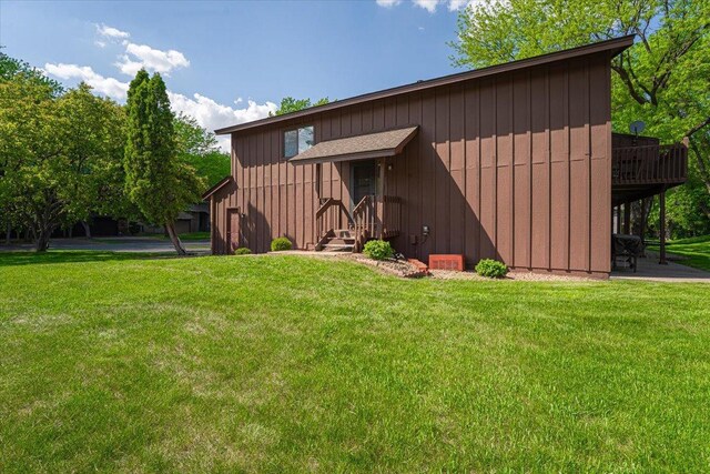 6900 Unity Ave N, Brooklyn Center, MN 55429 - view of front of home with a front lawn, board and batten siding, and a deck