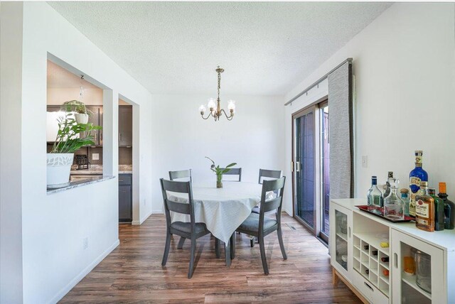6900 Unity Ave N, Brooklyn Center, MN 55429 - dining room with dark wood-type flooring, a chandelier, and a textured ceiling