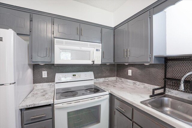6900 Unity Ave N, Brooklyn Center, MN 55429 - kitchen featuring white appliances, gray cabinetry, a sink, and backsplash