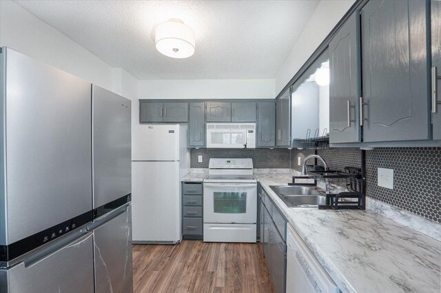 6900 Unity Ave N, Brooklyn Center, MN 55429 - kitchen with white appliances, a sink, gray cabinets, dark wood-style floors, and backsplash