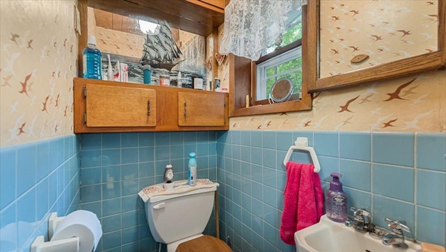 19157 181st Ave, Long Prairie, MN 56347 - bathroom featuring a sink, toilet, a wainscoted wall, and tile walls
