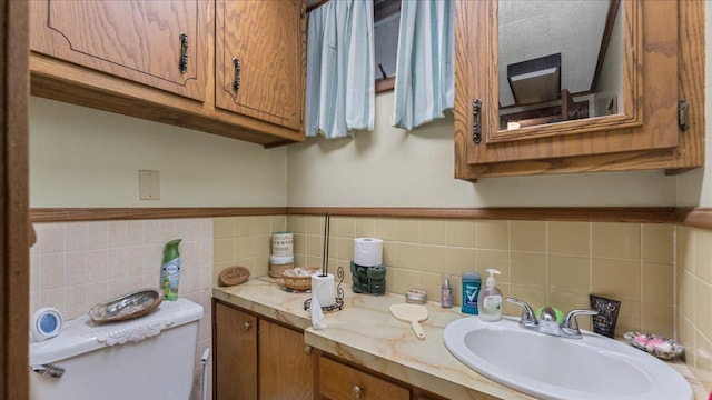 19157 181st Ave, Long Prairie, MN 56347 - bathroom featuring tile walls, vanity, toilet, and wainscoting