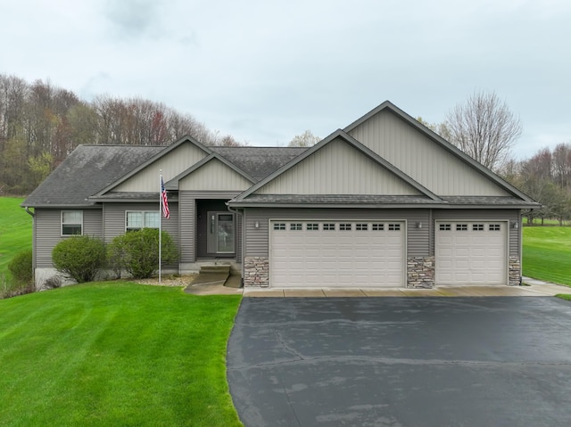 N5024 558th St, Menomonie, WI 54751 - craftsman house with driveway, an attached garage, a shingled roof, a front yard, and stone siding