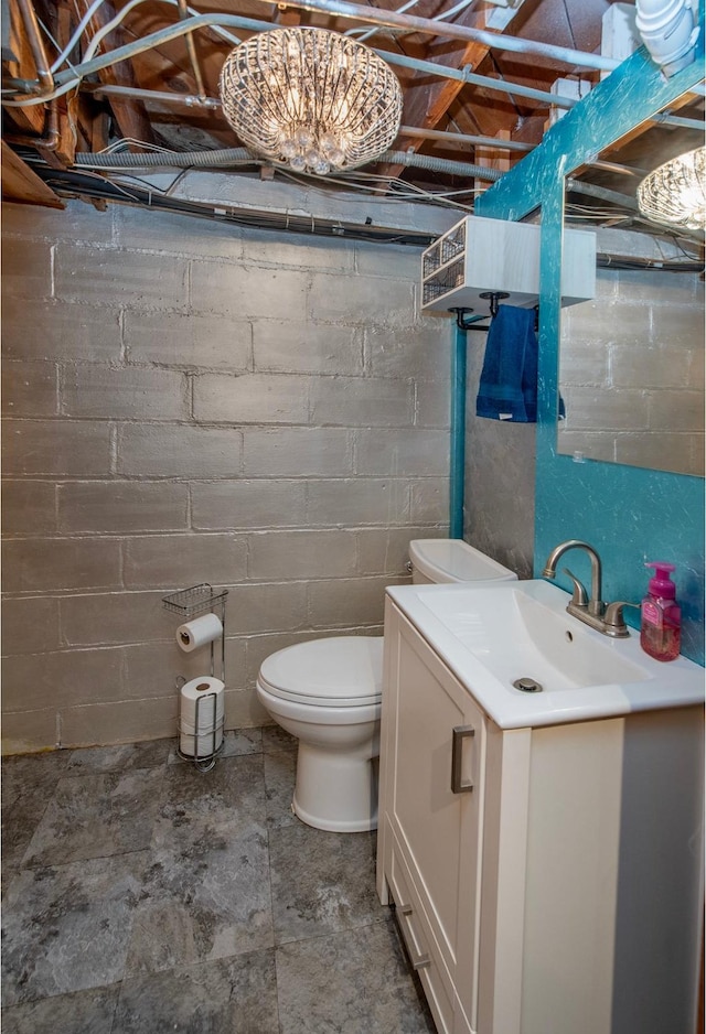 2159 Nortonia Ave, Saint Paul, MN 55119 - bathroom with toilet, vanity, and concrete block wall