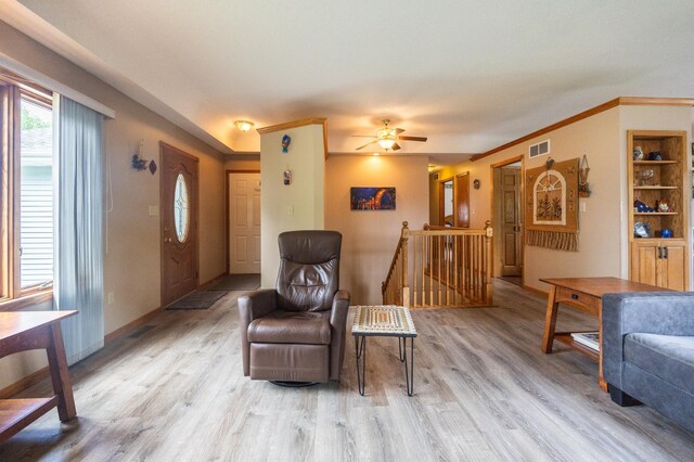 sitting room with an upstairs landing, light wood finished floors, a ceiling fan, and baseboards
