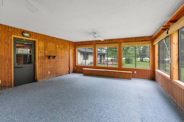 1242 4 1/4 St, Almena, WI 54805 - unfurnished sunroom featuring a ceiling fan, a textured ceiling, wooden walls, and carpet floors