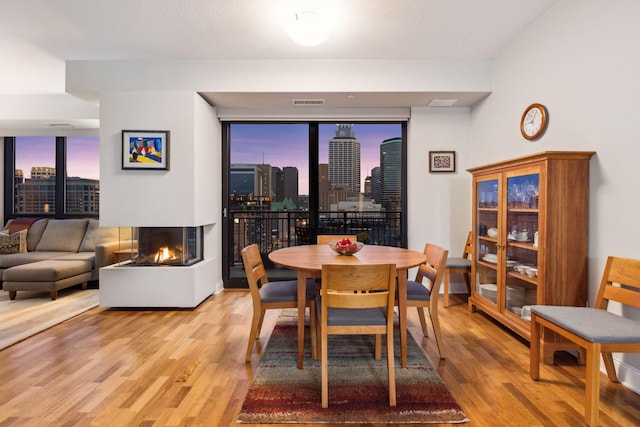 100 3rd Ave S Unit 1107, Minneapolis, MN 55401 - dining space featuring wood finished floors, a wall of windows, a multi sided fireplace, and a view of skyline