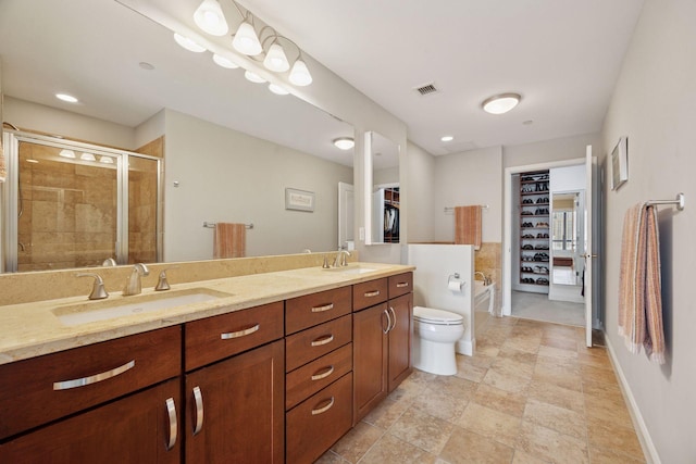 100 3rd Ave S Unit 1107, Minneapolis, MN 55401 - bathroom with double vanity, a shower stall, toilet, a spacious closet, and baseboards