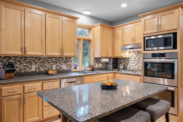 1665 3rd St SW, New Brighton, MN 55112 - kitchen featuring a sink, appliances with stainless steel finishes, light brown cabinetry, under cabinet range hood, and a breakfast bar