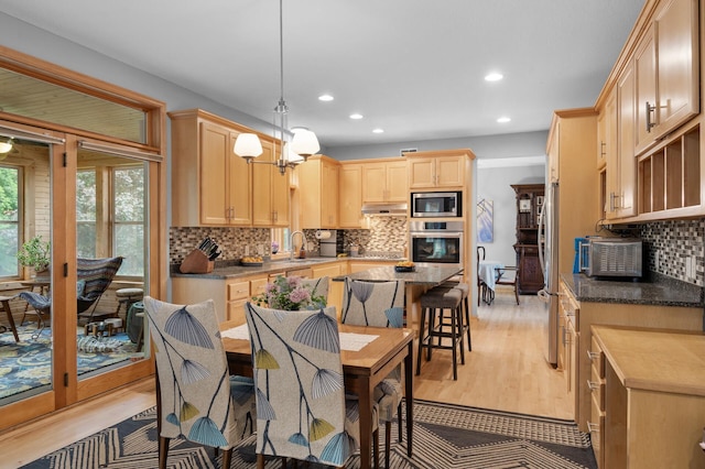 1665 3rd St SW, New Brighton, MN 55112 - kitchen featuring appliances with stainless steel finishes, light brown cabinets, recessed lighting, decorative backsplash, and under cabinet range hood
