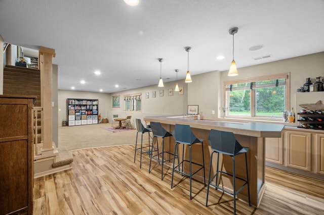 1665 3rd St SW, New Brighton, MN 55112 - kitchen featuring a breakfast bar, light wood-style floors, recessed lighting, light countertops, and pendant lighting