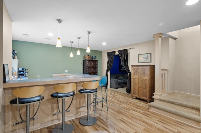 1665 3rd St SW, New Brighton, MN 55112 - kitchen featuring light wood-style flooring, a kitchen bar, recessed lighting, pendant lighting, and a peninsula