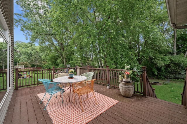 1665 3rd St SW, New Brighton, MN 55112 - deck with outdoor dining space, a yard, and view of wooded area