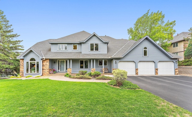 2501 112th St, Bloomington, MN 55431 - traditional home featuring covered porch, a front lawn, a garage, asphalt driveway, and roof with shingles