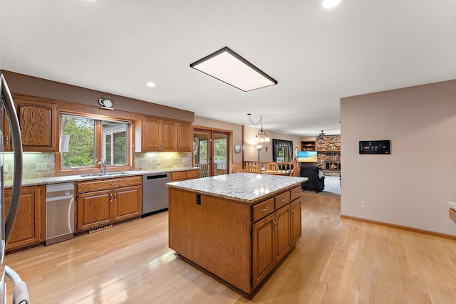 2501 112th St, Bloomington, MN 55431 - kitchen with dishwasher, a kitchen island, brown cabinetry, a sink, and recessed lighting