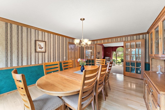 2501 112th St, Bloomington, MN 55431 - dining area with light wood-style flooring, wallpapered walls, a chandelier, and ornamental molding