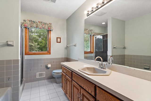 2501 112th St, Bloomington, MN 55431 - bathroom featuring tile walls, tile patterned flooring, a stall shower, a wainscoted wall, and vanity