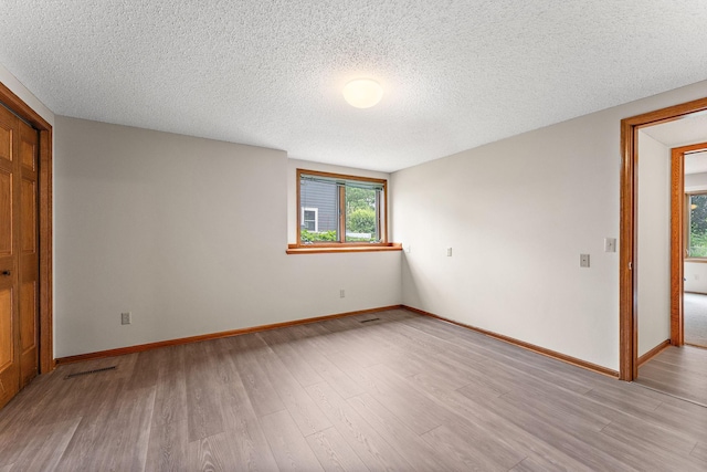 2501 112th St, Bloomington, MN 55431 - empty room featuring light wood-type flooring, a textured ceiling, and baseboards