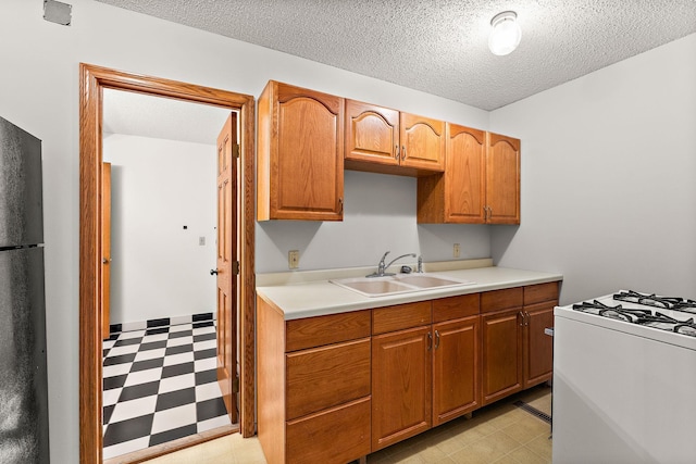 2501 112th St, Bloomington, MN 55431 - kitchen featuring light flooring, a sink, gas range gas stove, light countertops, and freestanding refrigerator