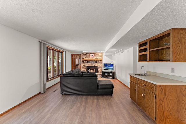 2501 112th St, Bloomington, MN 55431 - living area featuring a textured ceiling, light wood-style floors, a fireplace, and baseboards