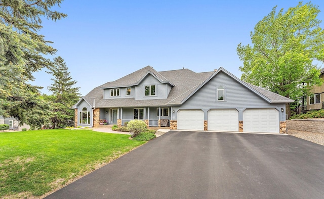 2501 112th St, Bloomington, MN 55431 - view of front of house with a porch, a garage, asphalt driveway, a front yard, and a shingled roof