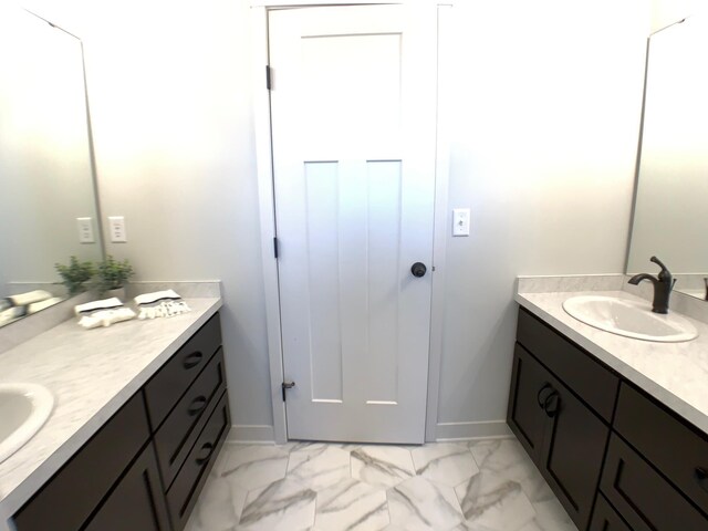 4605 130th Ln NE, Blaine, MN 55449 - bathroom with two vanities, marble look tile flooring, and baseboards