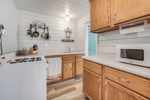 23873 Arcade Loop, Crow Wing Lake Twp, MN 56464 - kitchen with white appliances, light wood-type flooring, light countertops, a sink, and wood walls