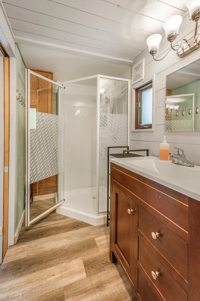 23873 Arcade Loop, Crow Wing Lake Twp, MN 56464 - bathroom featuring wood finished floors, a stall shower, and vanity