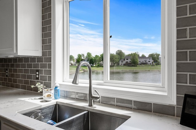 2940 Tiflawn Ct, Shakopee, MN 55379 - kitchen view of a sink, tasteful backsplash, light stone countertops, a water view, and white cabinets