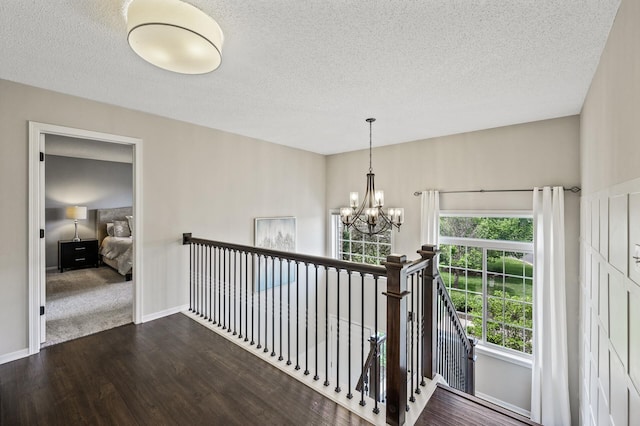 2940 Tiflawn Ct, Shakopee, MN 55379 - hallway with an upstairs landing, a chandelier, a textured ceiling, wood finished floors, and baseboards