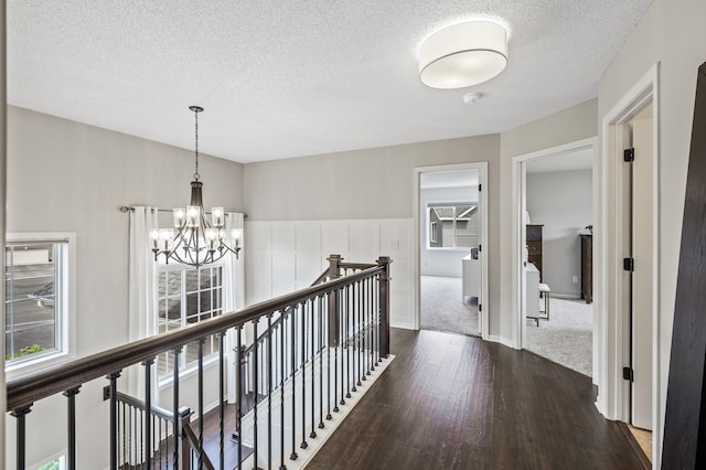 2940 Tiflawn Ct, Shakopee, MN 55379 - hall featuring an upstairs landing, dark wood-type flooring, a chandelier, and a textured ceiling