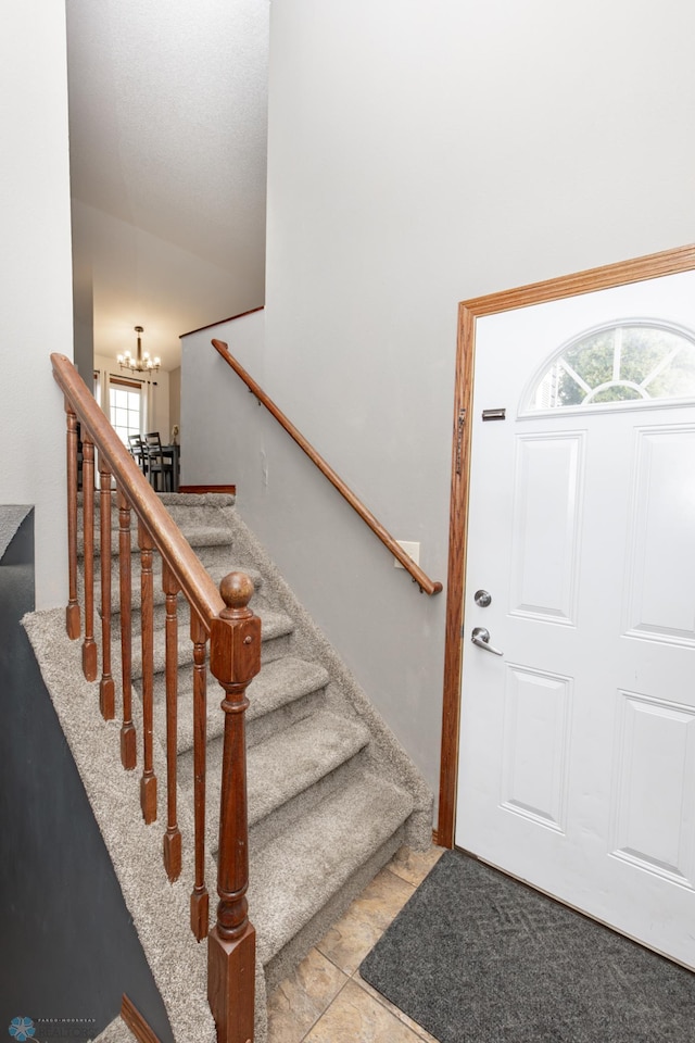 foyer featuring a chandelier and stairway
