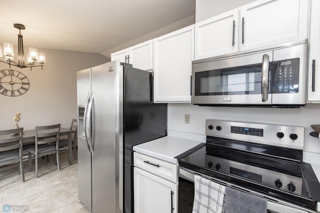 kitchen with appliances with stainless steel finishes, a chandelier, white cabinets, light countertops, and decorative light fixtures