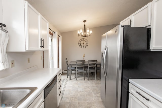 kitchen featuring stainless steel appliances, a chandelier, white cabinets, a sink, and light countertops