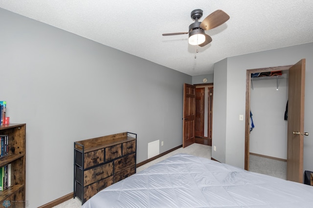 bedroom featuring light colored carpet, baseboards, a ceiling fan, and a closet