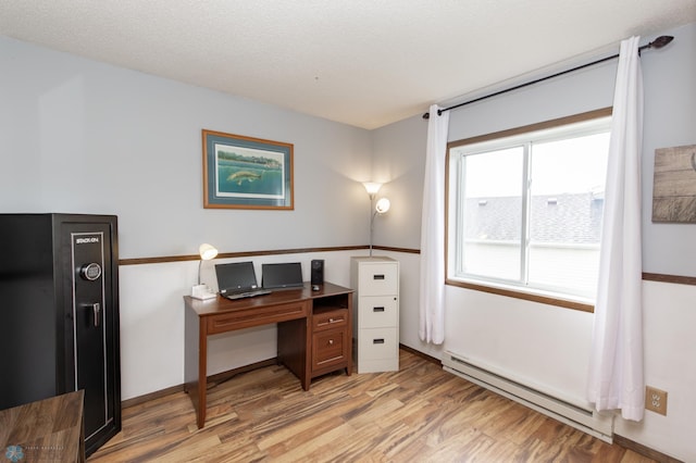 office area featuring a baseboard heating unit and light wood-style floors