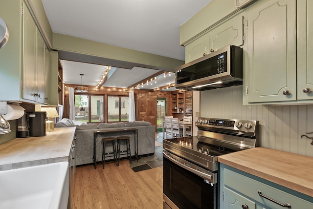 4236 Salem Ave, Saint Louis Park, MN 55416 - kitchen featuring appliances with stainless steel finishes, open floor plan, green cabinetry, light wood-style floors, and wooden counters
