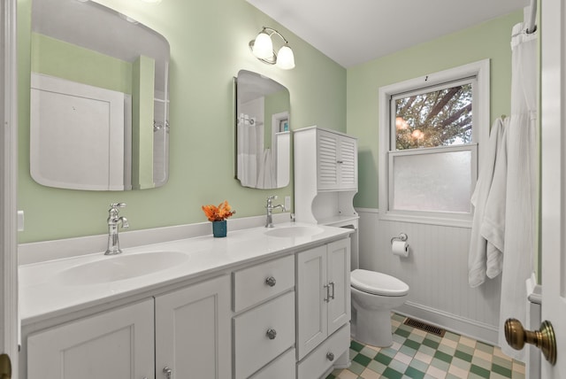 4236 Salem Ave, Saint Louis Park, MN 55416 - bathroom with double vanity, toilet, a wainscoted wall, and tile patterned floors