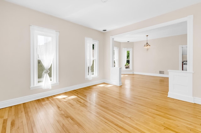 4304 Colfax Ave S, Minneapolis, MN 55409 - empty room with light wood-style floors, baseboards, and a chandelier