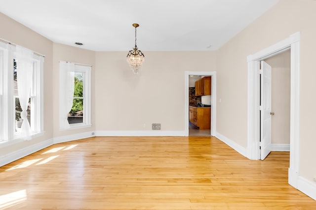 4304 Colfax Ave S, Minneapolis, MN 55409 - unfurnished room featuring light wood-style floors, a chandelier, and baseboards