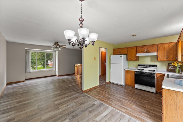 9013 91st St S, Cottage Grove, MN 55016 - kitchen with white appliances, under cabinet range hood, light countertops, a chandelier, and light wood-style flooring