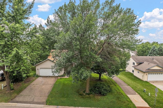 9013 91st St S, Cottage Grove, MN 55016 - view of front facade featuring concrete driveway, a front yard, and an attached garage