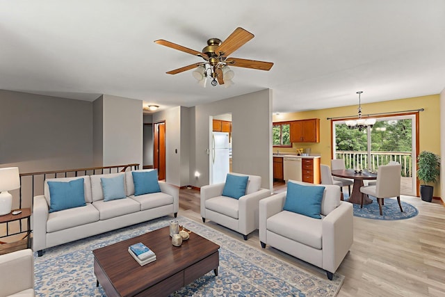9013 91st St S, Cottage Grove, MN 55016 - living room featuring light wood-type flooring, a ceiling fan, and a chandelier