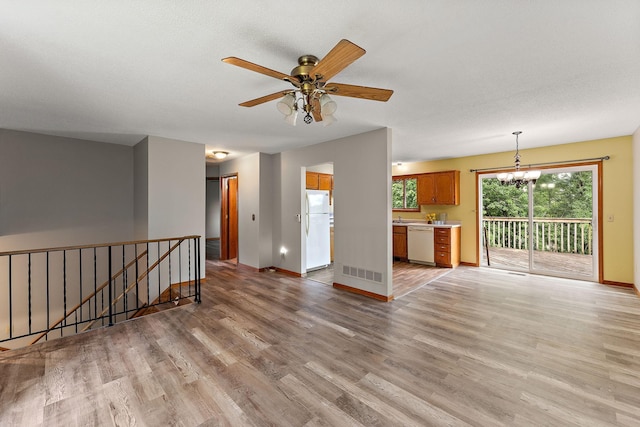 9013 91st St S, Cottage Grove, MN 55016 - unfurnished living room with a chandelier, light wood-type flooring, and a ceiling fan