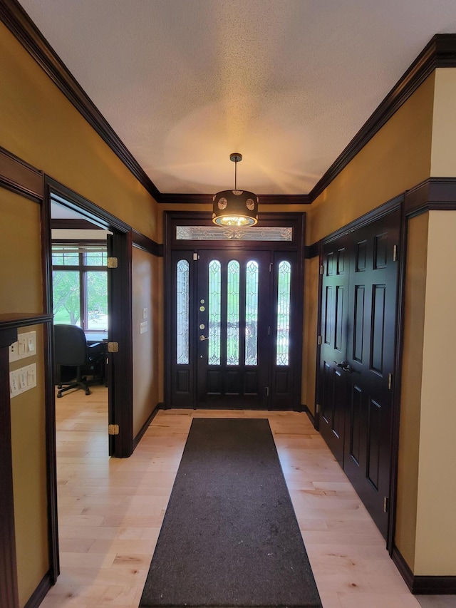 1605 26th St SE, Saint Cloud, MN 56304 - entrance foyer featuring light wood-style floors, ornamental molding, a textured ceiling, and baseboards
