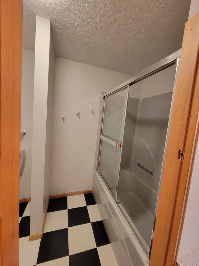 1605 26th St SE, Saint Cloud, MN 56304 - bathroom featuring tile patterned floors, shower / bath combination with glass door, and a textured ceiling